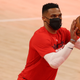 Russell Westbrook shoots around in a face mask.